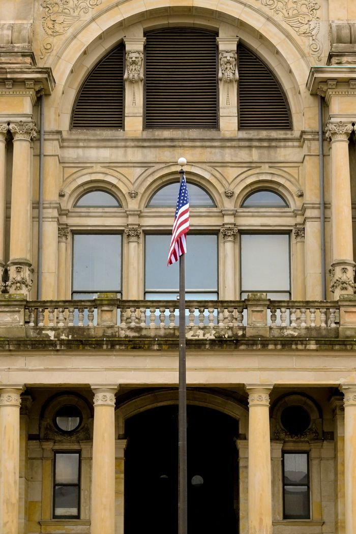 A historic civic building with an American flag, representing the court process