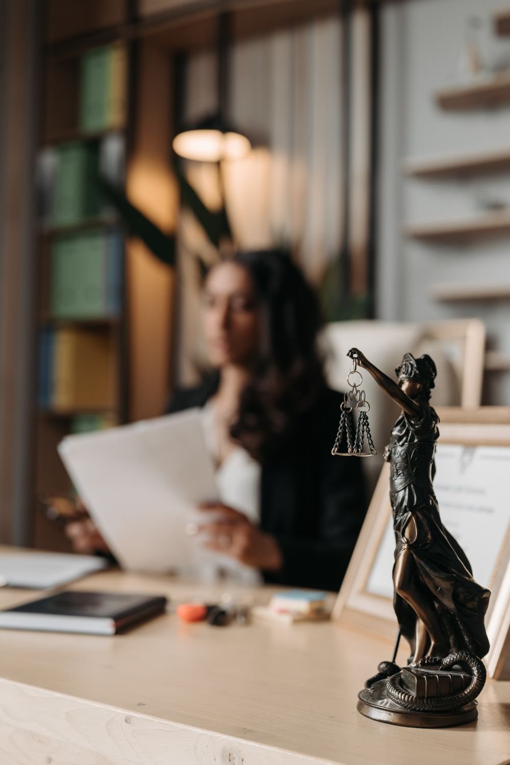 A legal professional reviewing case papers behind a scales-of-justice figure
