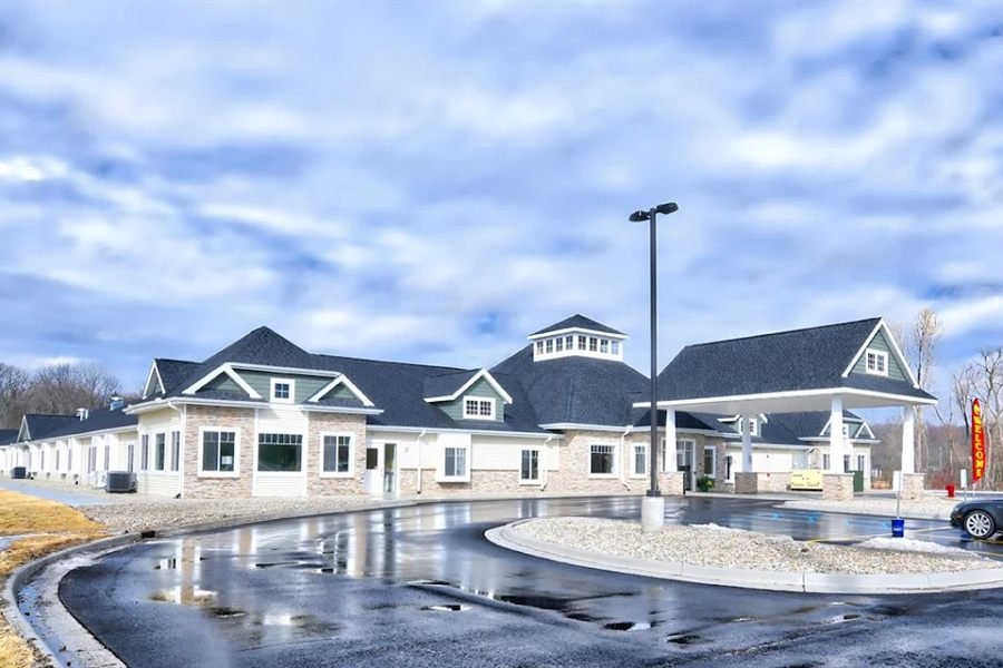 Exterior of a newly built assisted living and memory care community with a covered entrance