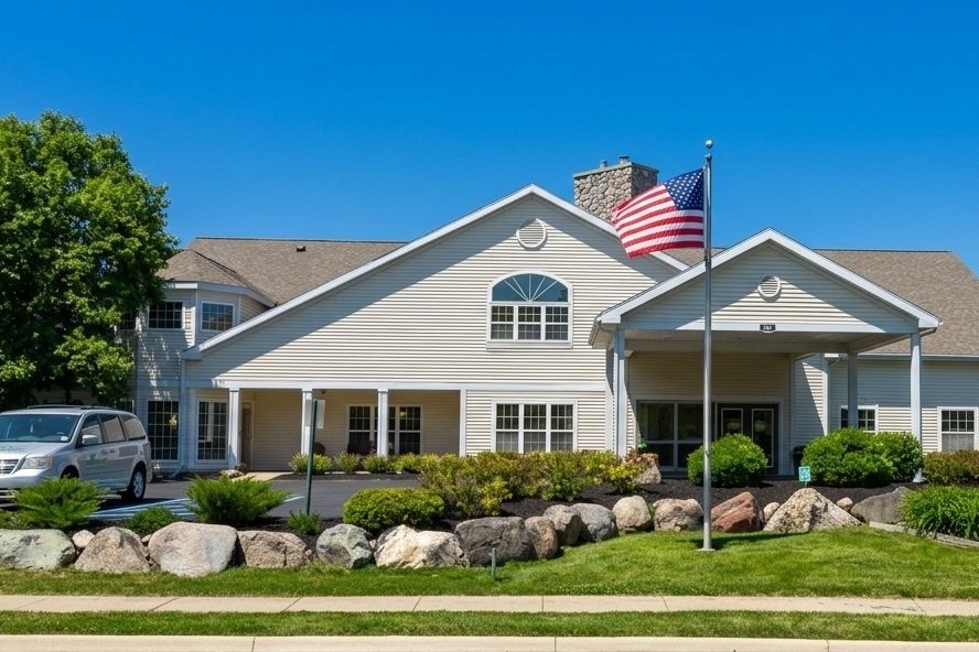 Assisted living community entrance with a flagpole and stone landscaping