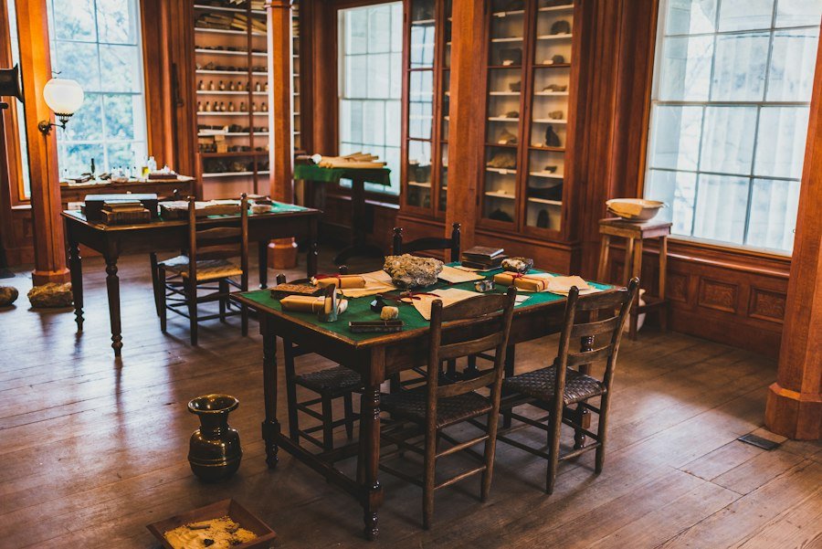 A warm library room with chairs set around a table