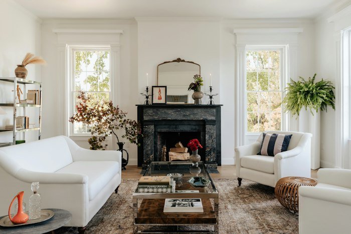 A bright, airy community living room with a fireplace and white sofas