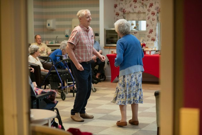 Residents dancing together in a lively community hall